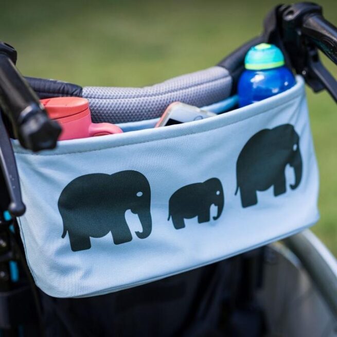 Bundlebean wheelchair bag in elephant design shown on handles of manual wheelchair buggy