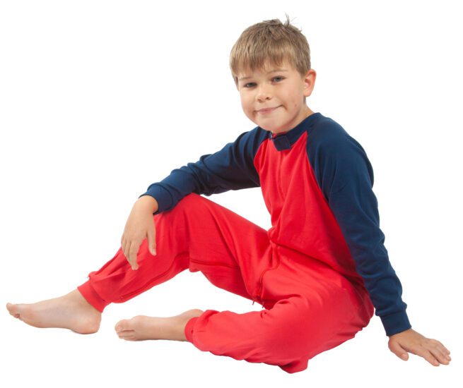 Boy in red and navy front opening sleepsuit sat down