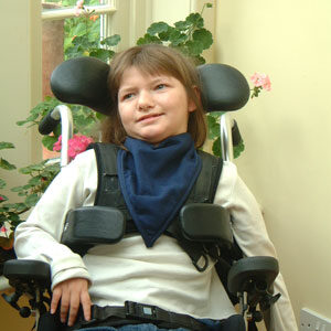 Young girl wearing blue kerchief sat in wheelchair