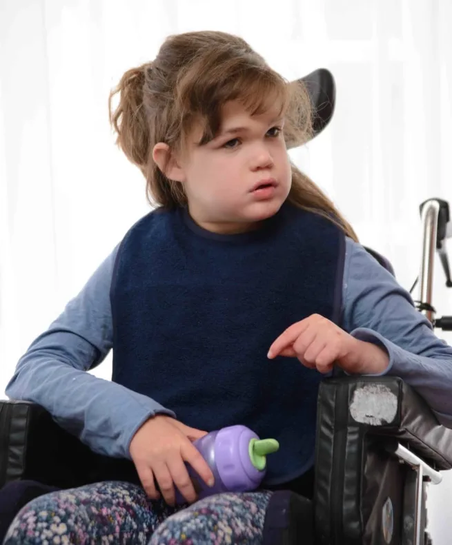 Girl in wheelchair wearing navy bamboo towelling apron