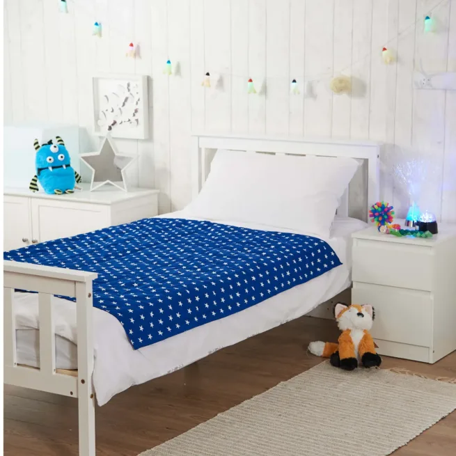 Photo of bedroom with blue star weighted blanket on bed