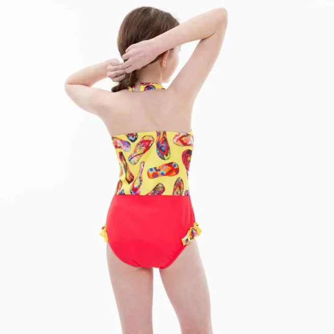 Girl wearing Kes Vir incontinence swimsuit in marigold and coral colour with flip flop design - Back view