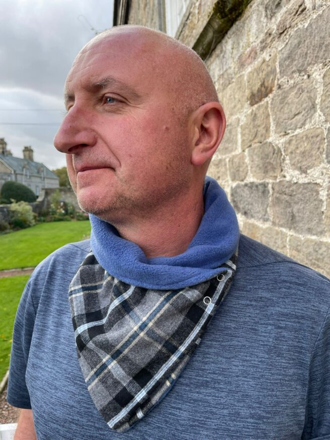 Man wearing blue and grey check neck wrap