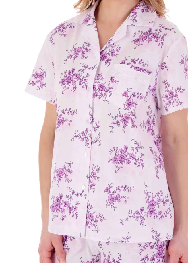 Close up of woman wearing pyjama top with olum floral design with velcro fastenings