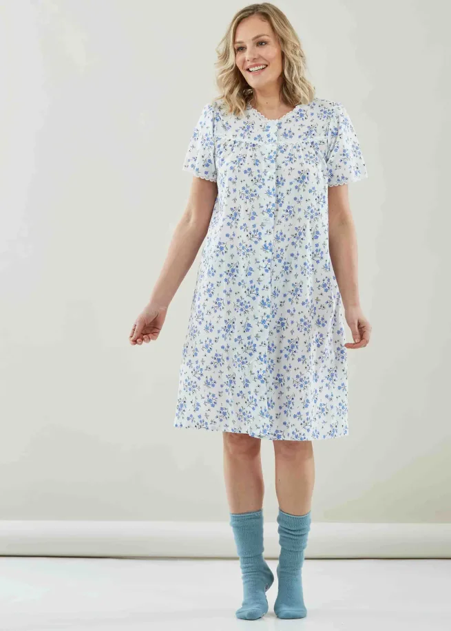 Woman standing wearing knee length jenny blue floral nightdress and blue socks