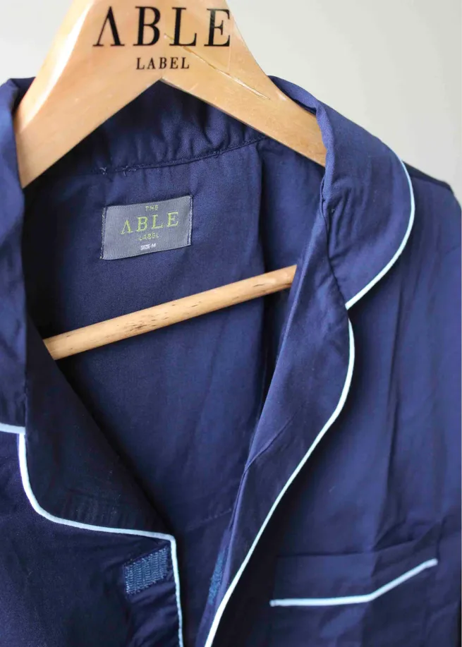 Close up of navy Maxwell pyjamas top with velcro fastening. Item on wooden hanger.