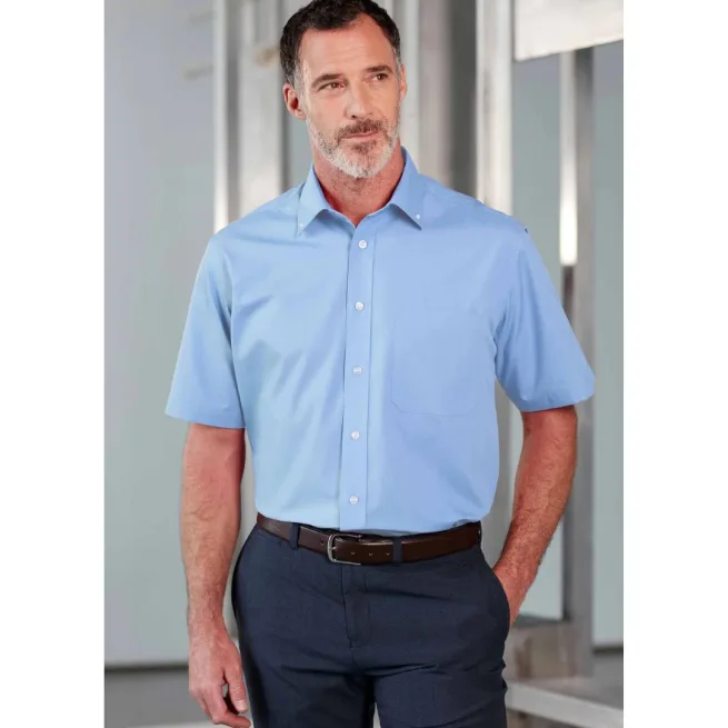 Man standing wearing blue short sleeve shirt and navy blue trousers