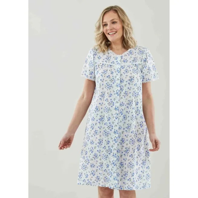 Woman standing wearing blue floral nightdress with velcro front fastenings