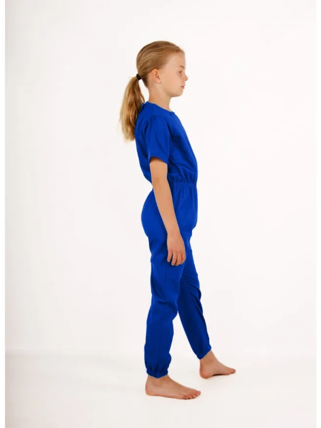 Girl standing wearing royal blue rip resistant bodysuit, short sleeves, long legs, side view